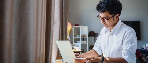 Young man researching cars on his laptop