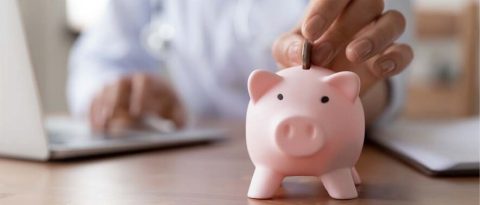 a person putting a coin into a piggy-bank