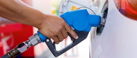 A blue fuel pump inserted into a white vehicle. 